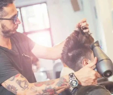 A man getting his hair cut at a barber shop, highlighting modern men hairstyles undercut.