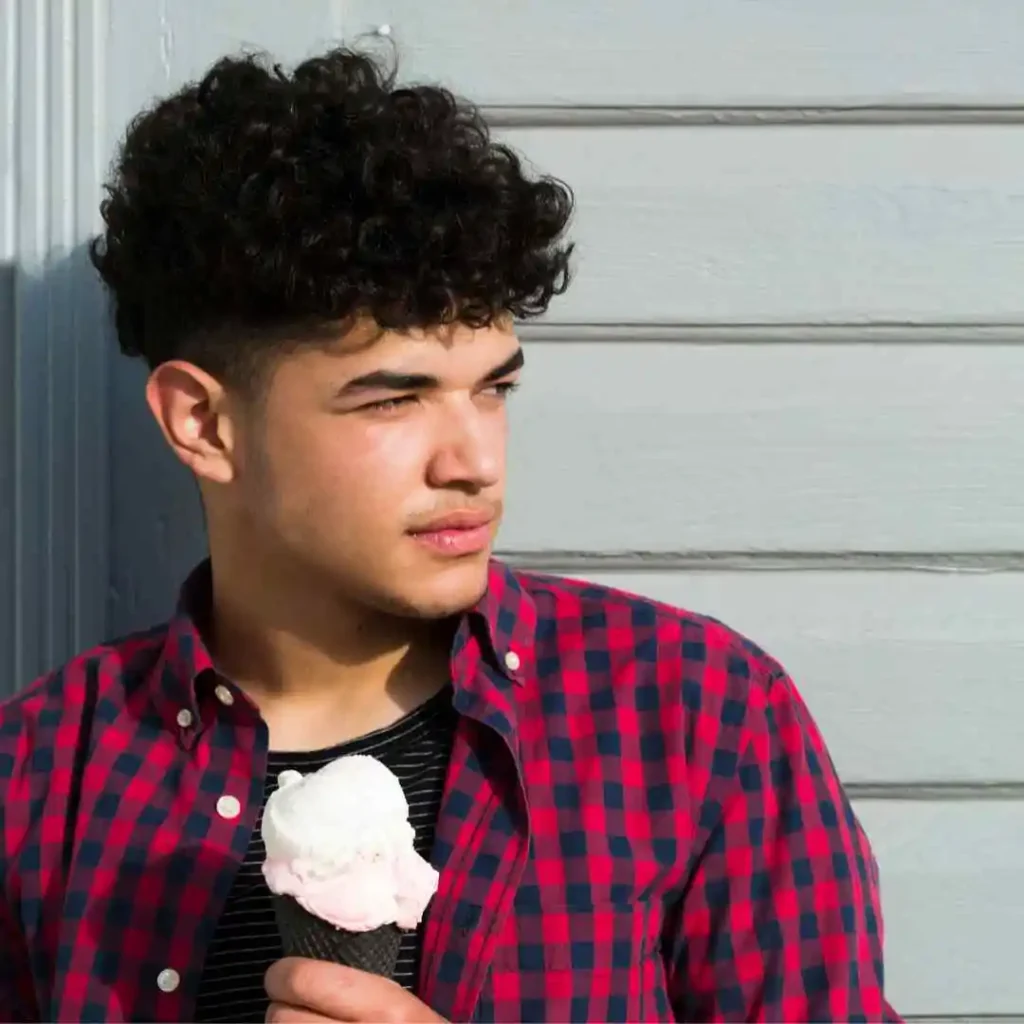 a young man is holding an ice cream cone