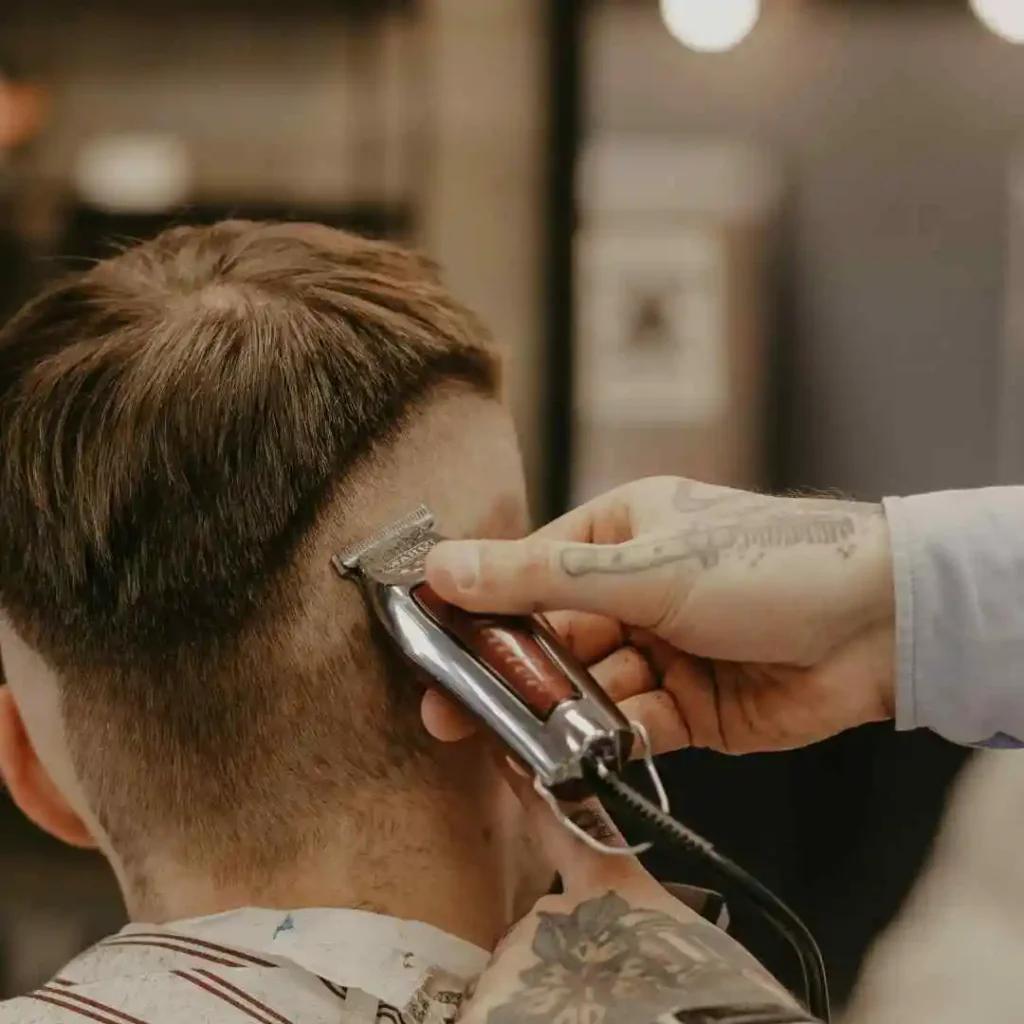 a man getting his hair cut by a barber