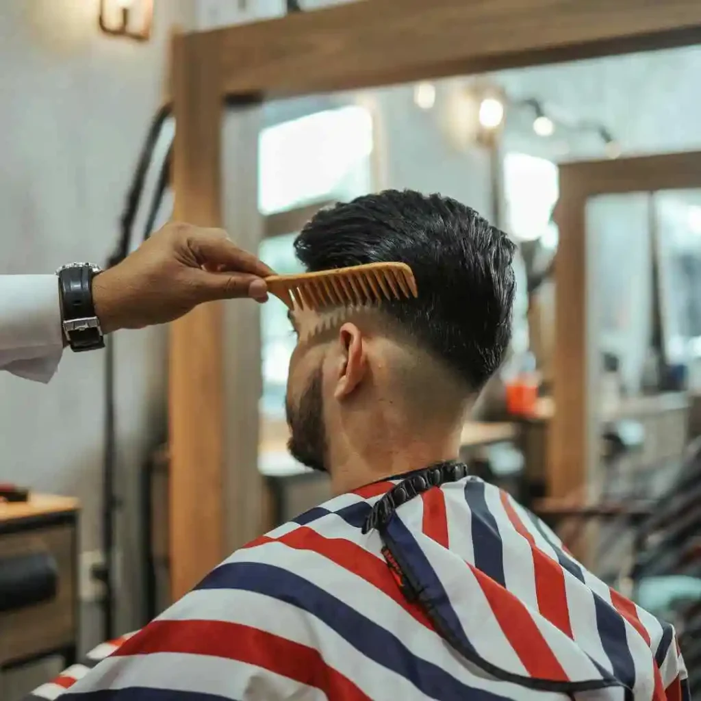 a man getting his hair cut at a barber shop