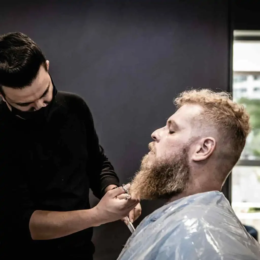 a man getting his hair cut by a barber