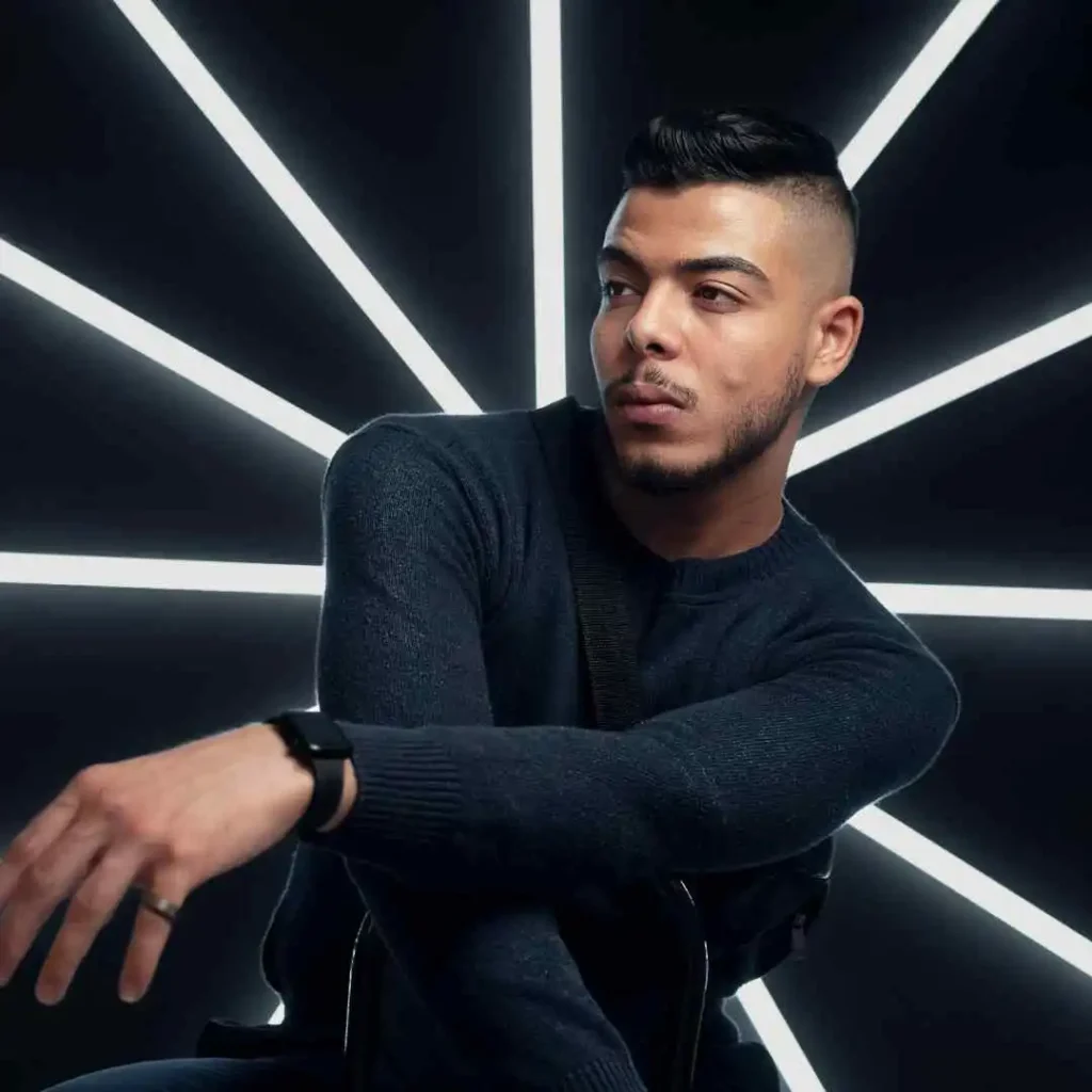 a man sitting in front of a black background