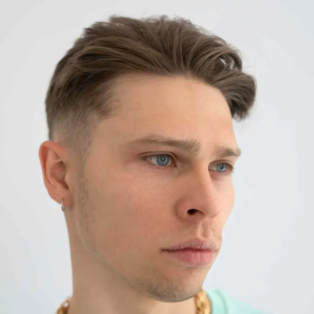 a man with a messy haircut and a necklace