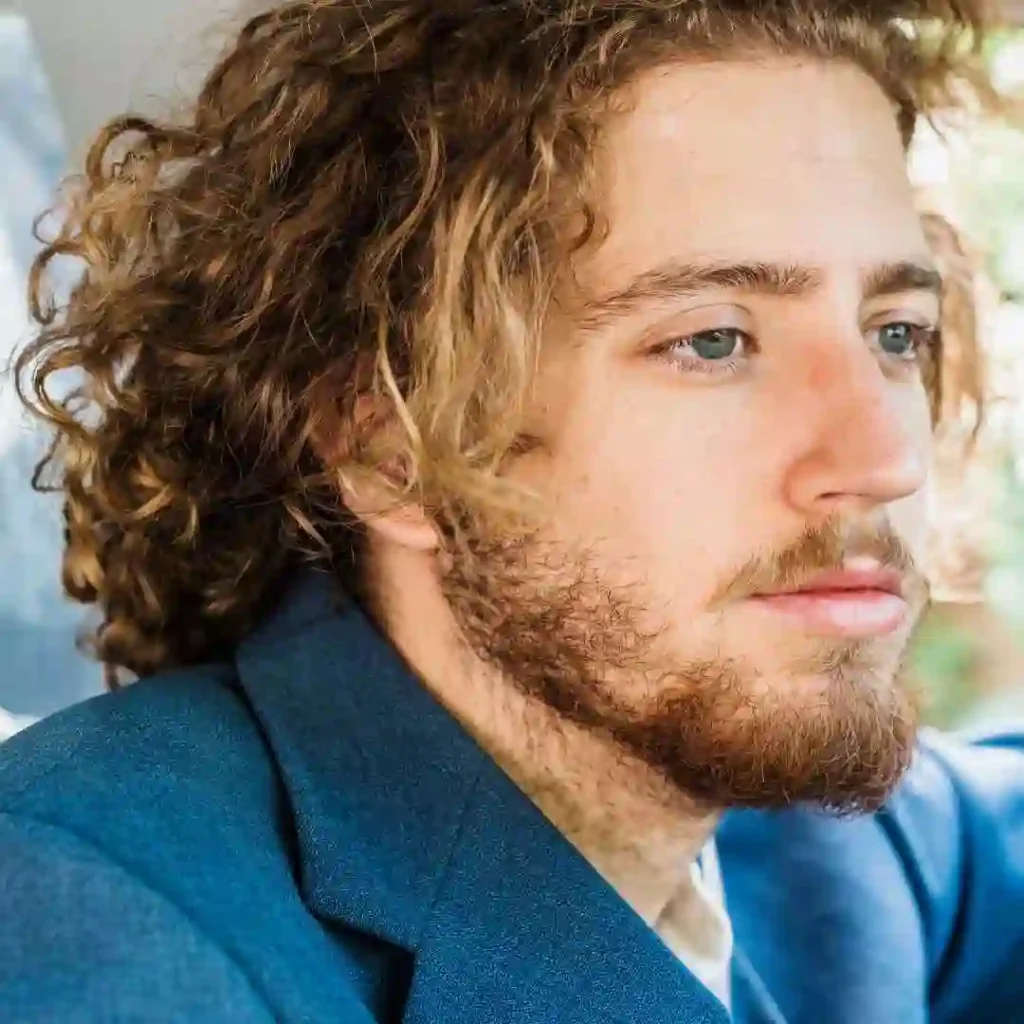 a close up of a person wearing a suit and tie