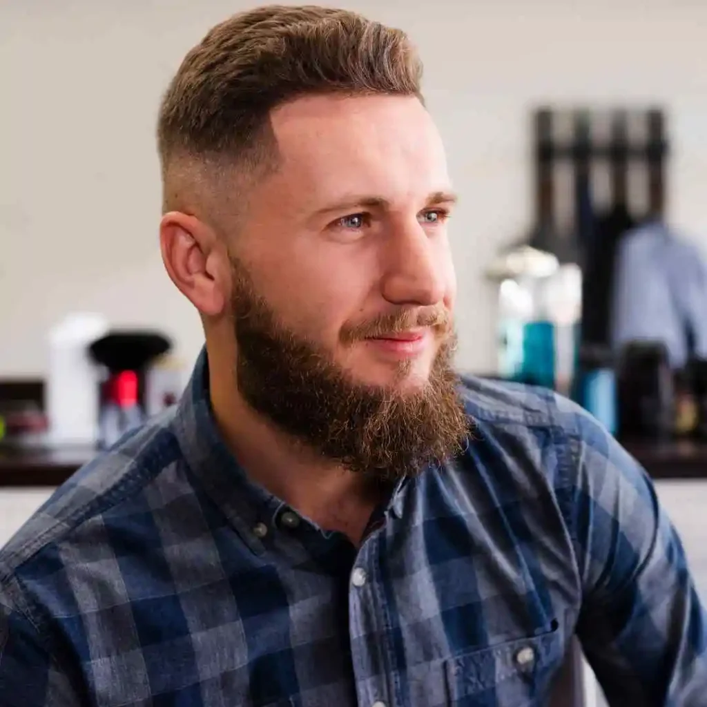 a man with a beard sitting in a room