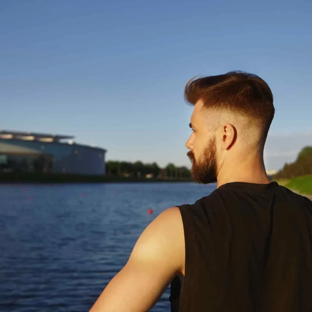 a man standing next to a body of water