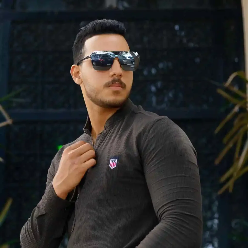 A man wearing sunglasses and a black shirt, exuding a cool and casual vibe, with a hairstyle that complements a long face shape. Men hairstyles long face.