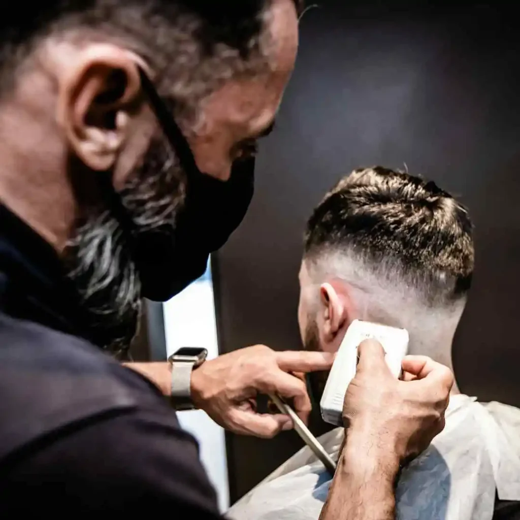 a man getting his hair cut by a barber