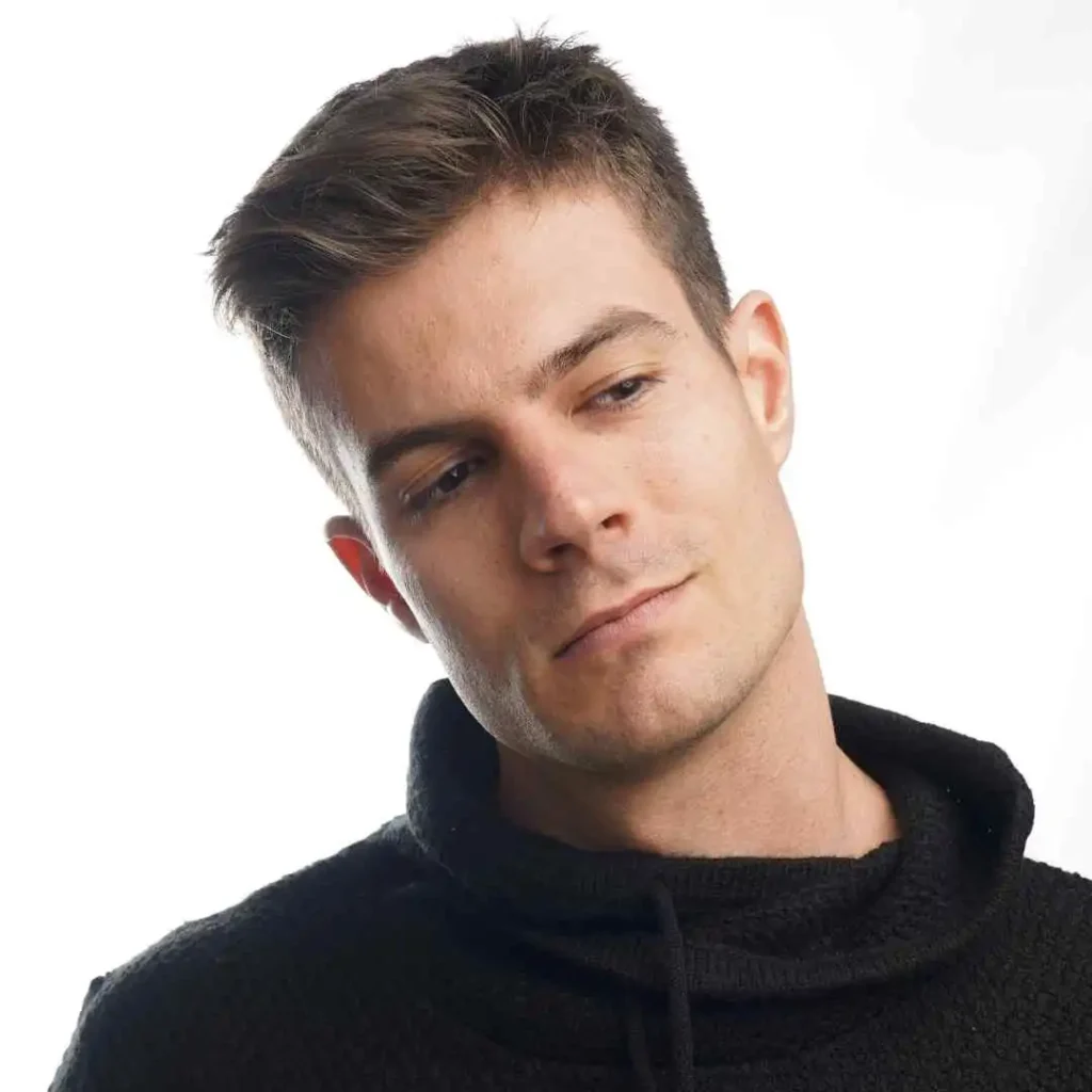 a man in a black sweater looking at the camera