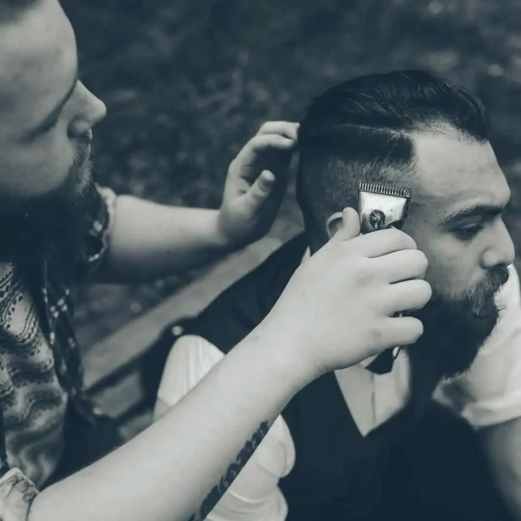 a man getting his hair cut by a woman