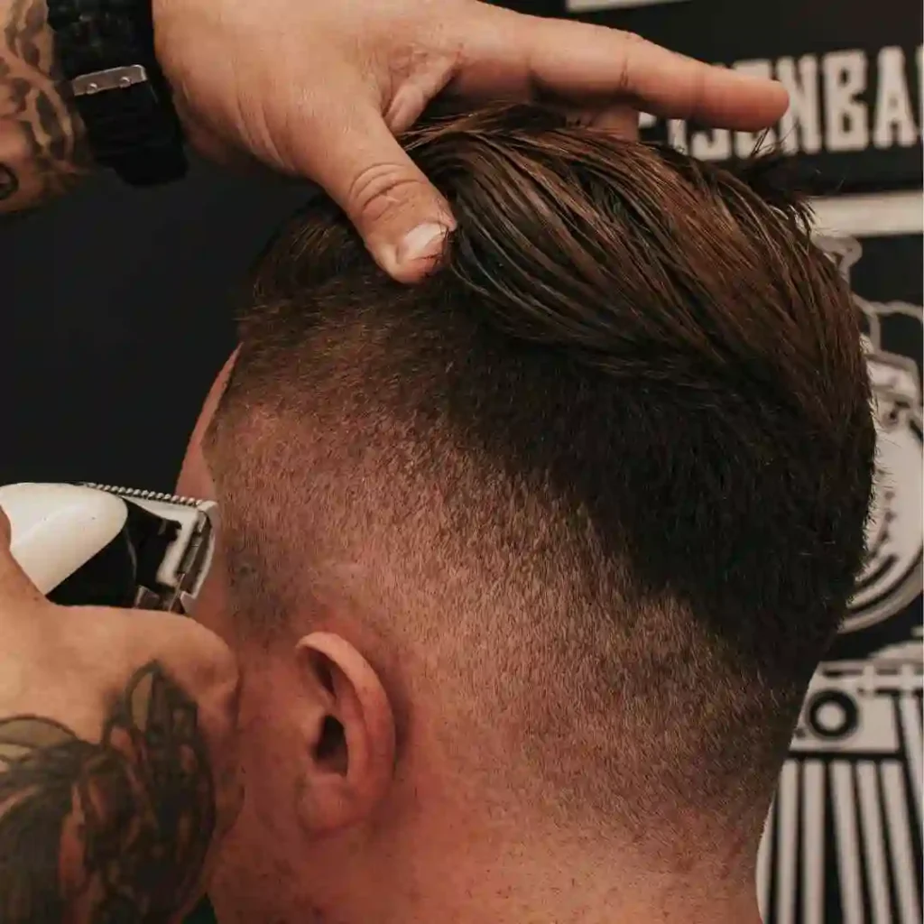 a man getting his hair cut at a barber shop