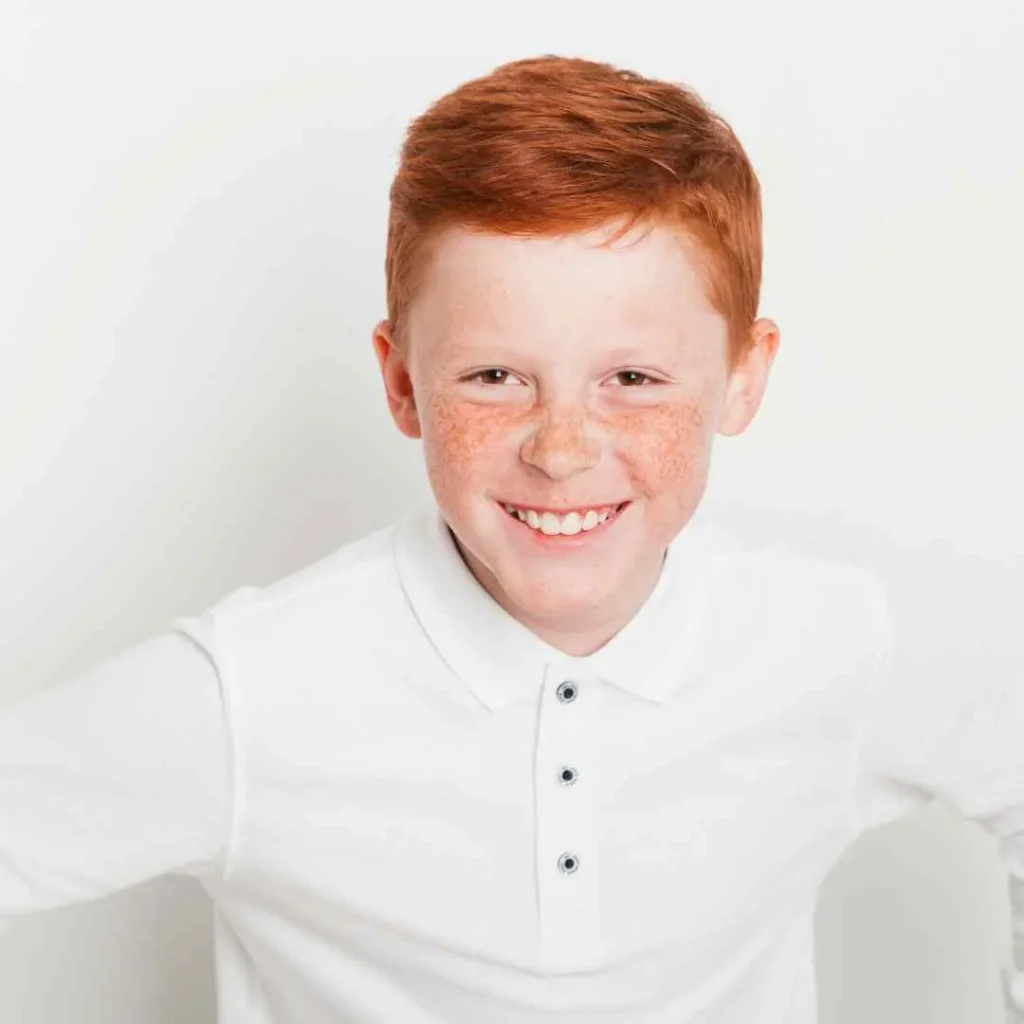 Person in a white shirt with brown hair against a light background.