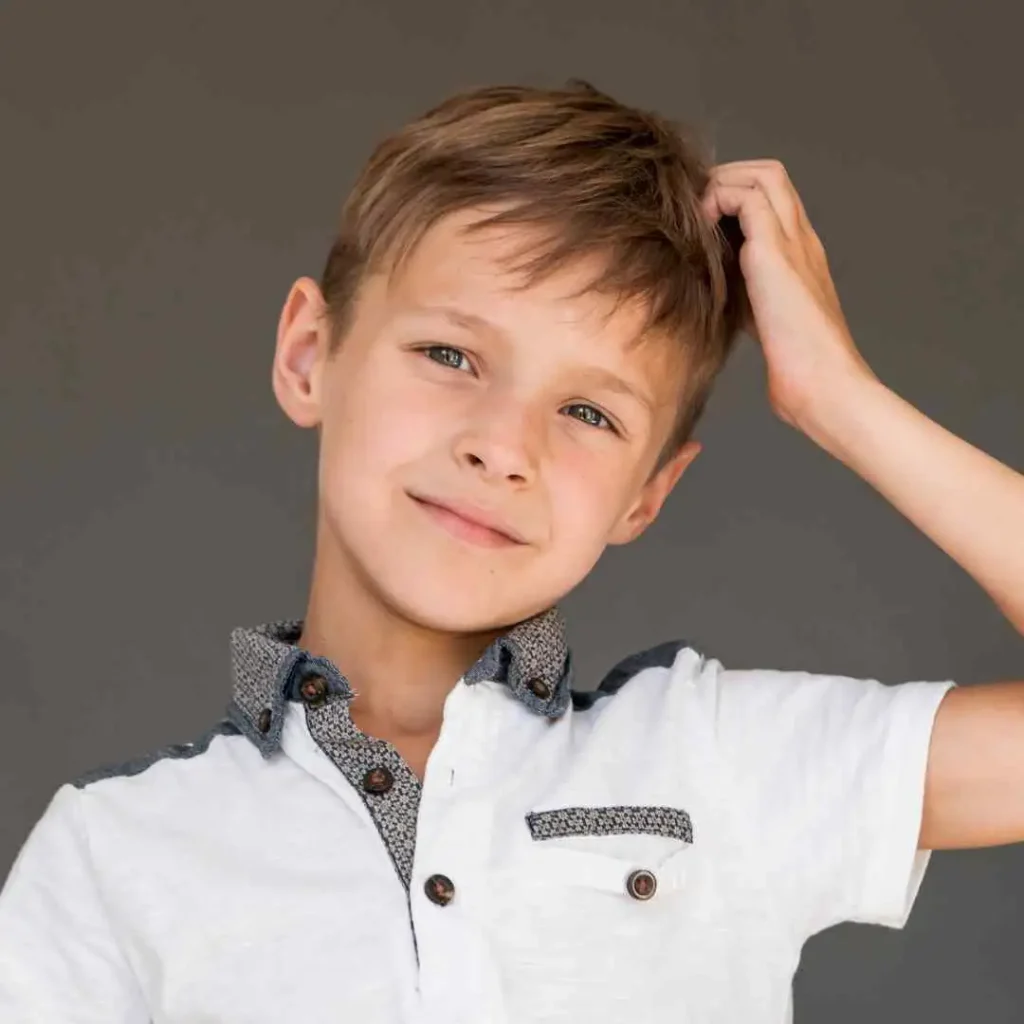 Person in a white shirt with patterned collar scratching their head.