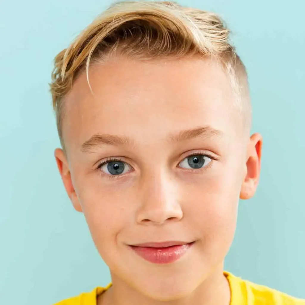 a young boy with blonde hair wearing a yellow shirt