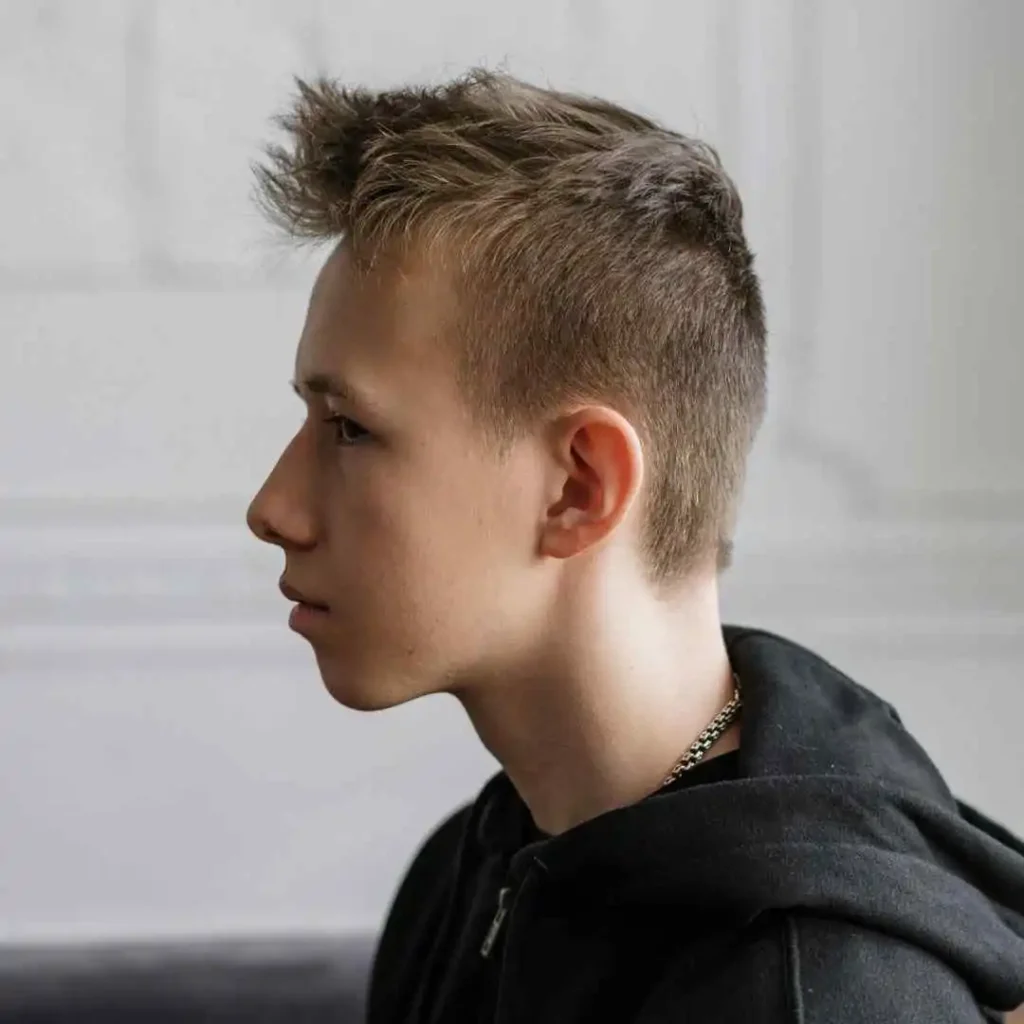 A young man with a short haircut and a hoodie, showcasing a trendy Teenage guy Haircuts.