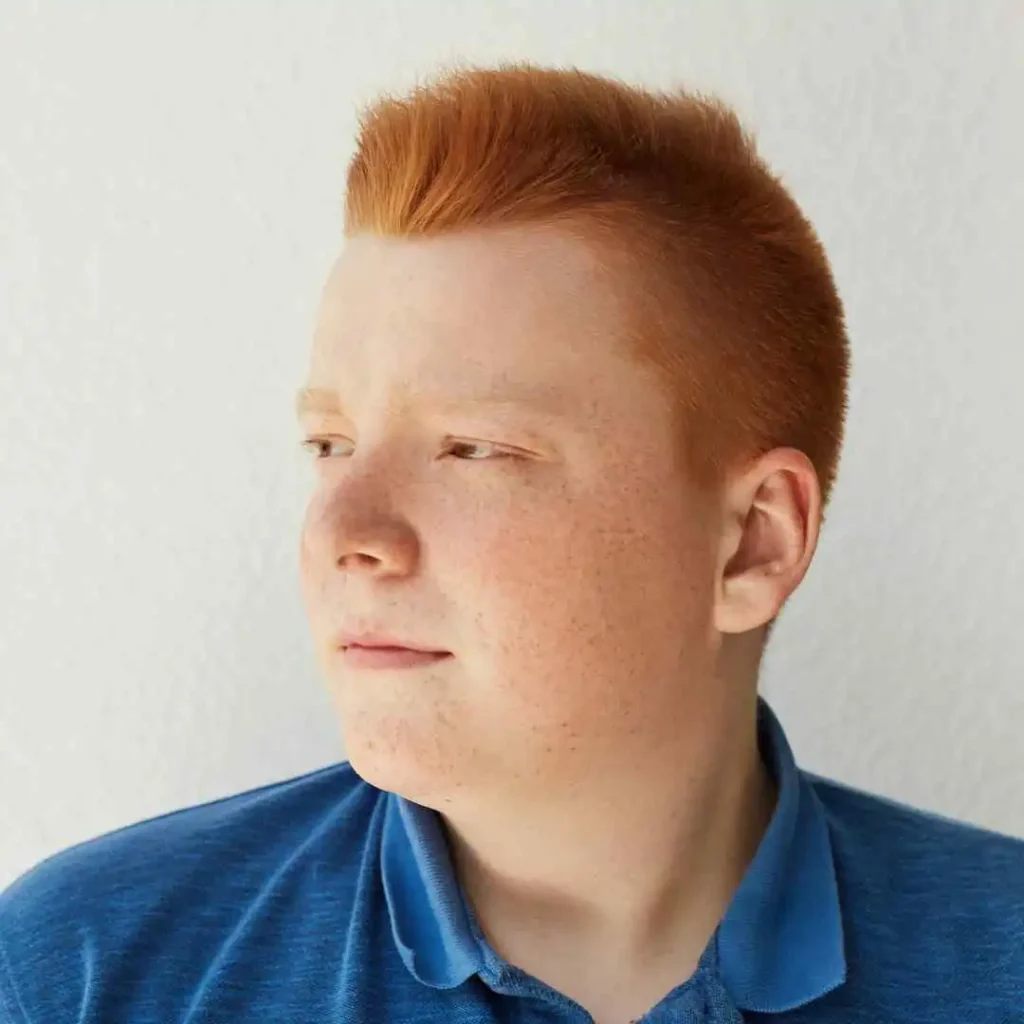 Person with short red hair wearing a blue polo shirt.