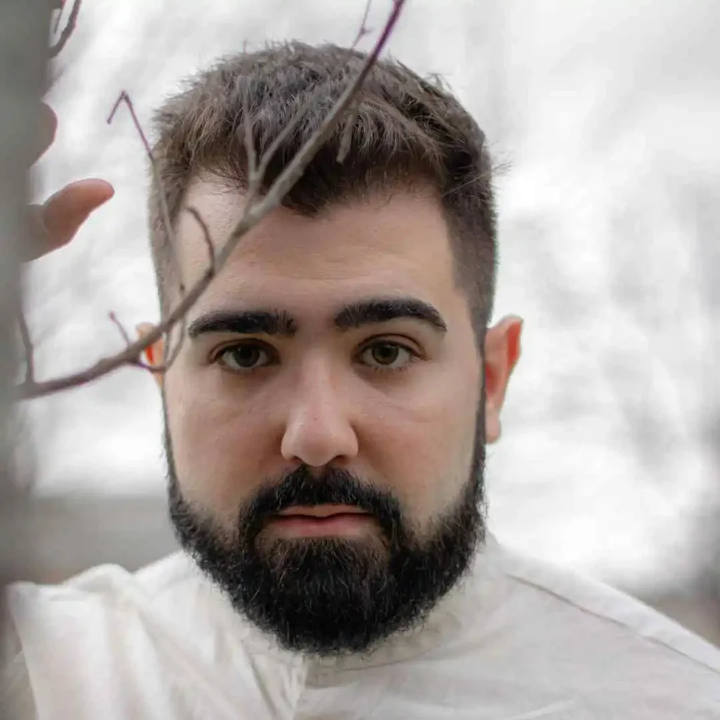 A close-up of a person with a beard, showcasing haircuts for men with diamond face.