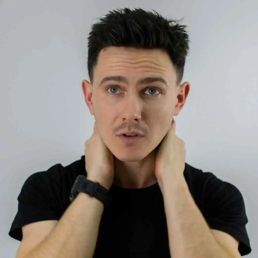 A man with his hands on his face, showcasing haircuts for men with diamond face.