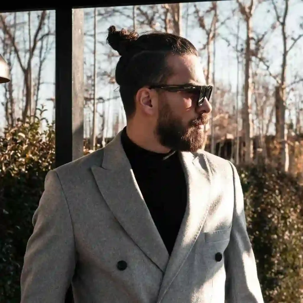 A man with a bun in his hair, showcasing haircuts for men with diamond face.