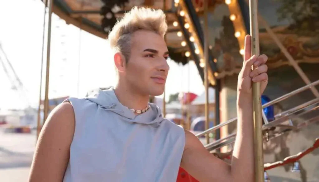 Person in sleeveless top holding a pole at a carousel, showcasing Mohawk men hairstyles.