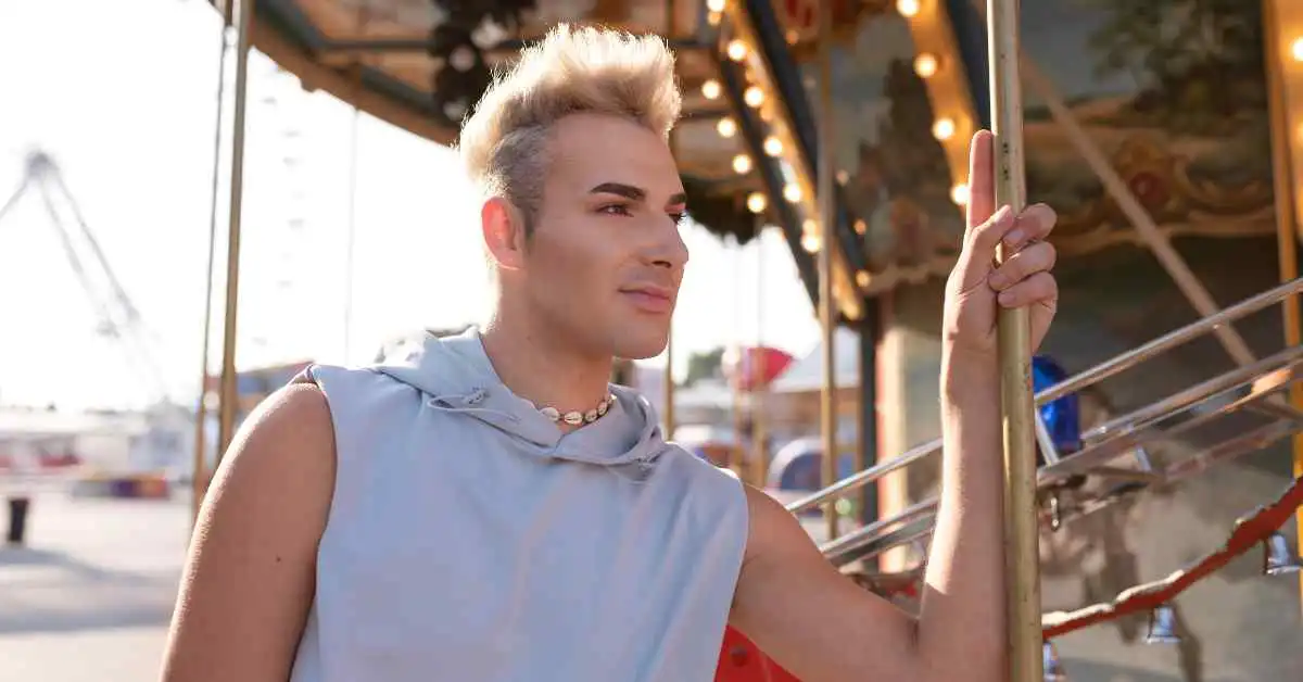 Person in sleeveless top holding a pole at a carousel, showcasing Mohawk men hairstyles.