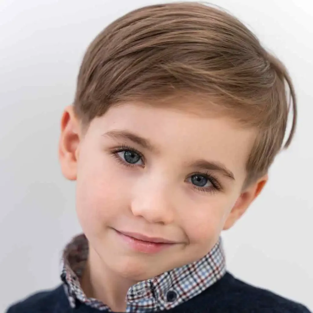 Child with brown hair in a checkered collar shirt and sweater.