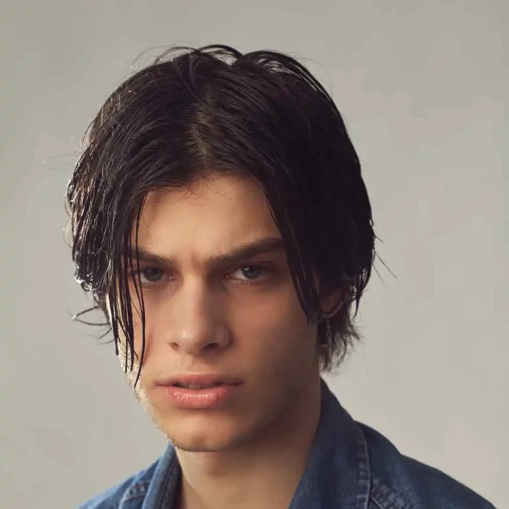 A man with long hair and a denim jacket, showcasing haircuts for men with diamond face.