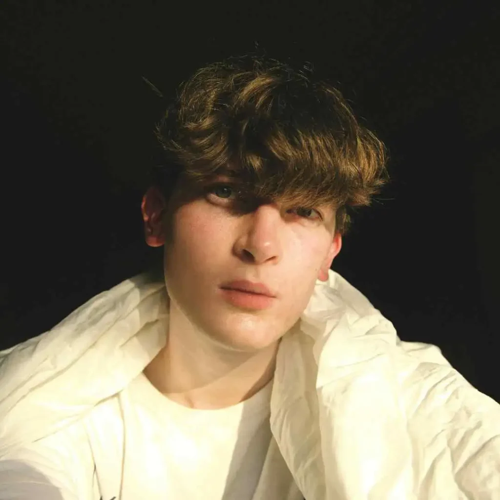 A young man is posing for a picture, showcasing haircuts for men with diamond face.