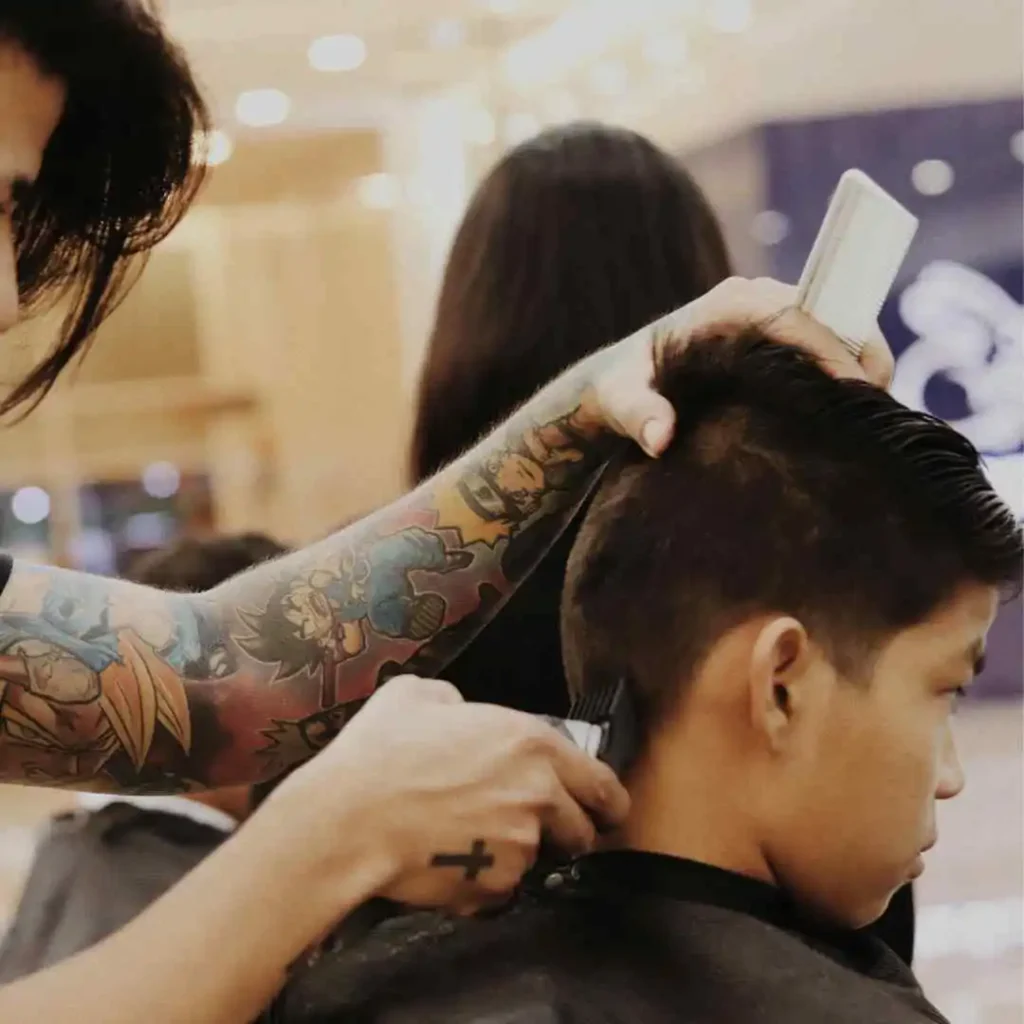 a young man getting his hair cut