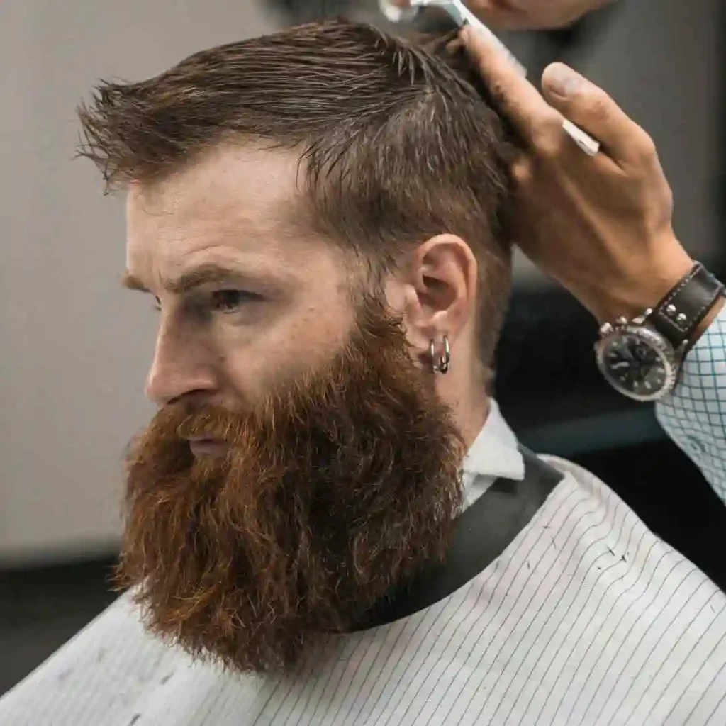 Top 15 Men Hairstyles for Buzz Cut 2 A barber styles a man's hair in a buzz cut, showcasing MEN HAIRSTYLES BUZZ CUT trends along with a well-groomed beard and a focused, professional atmosphere in the salon.