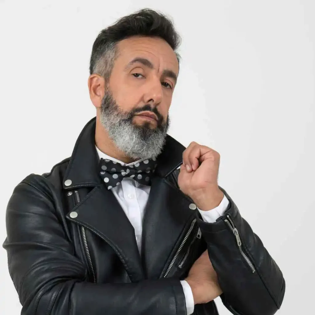 52 Mid-Length Hairstyles for Men- A Comprehensive Guide. 2 A man with a beard, wearing a bow tie, sporting a men's medium length hairstyle.