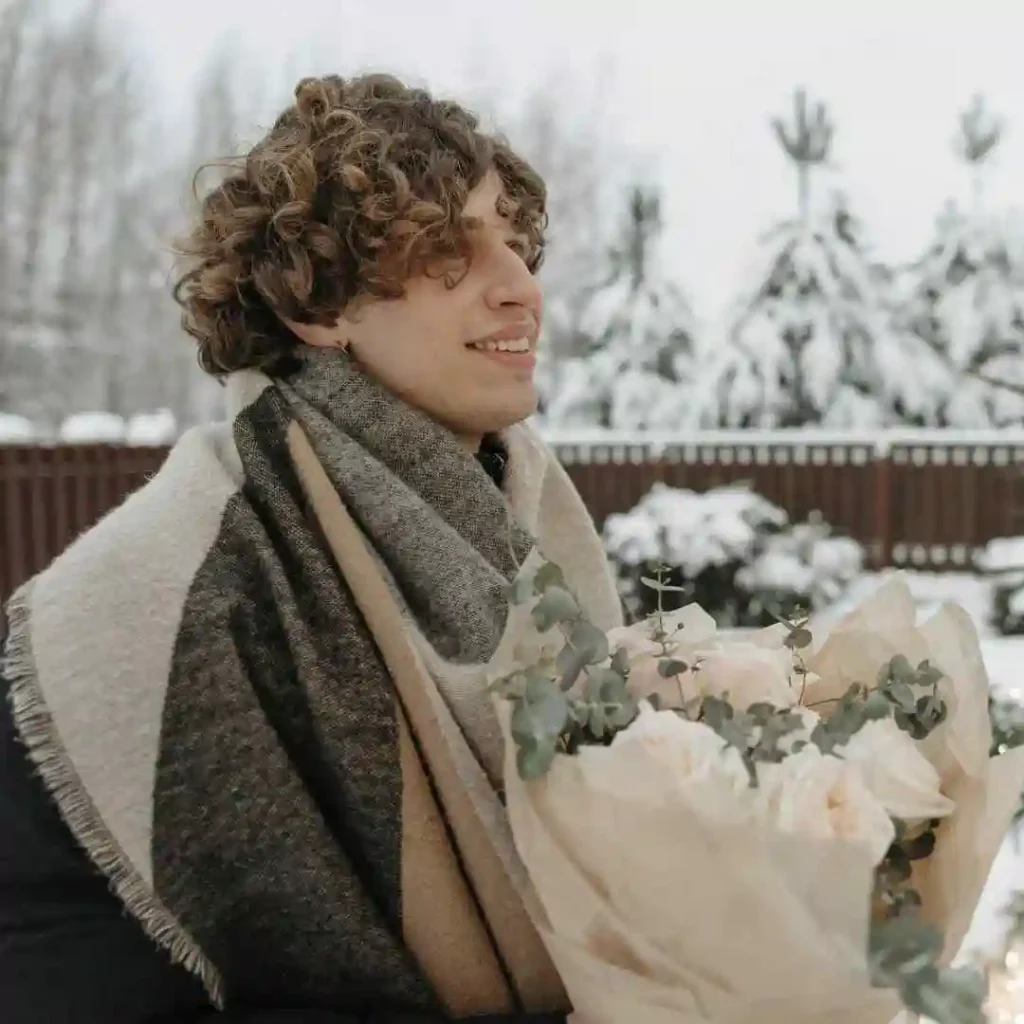a young man holding a bouquet of flowers