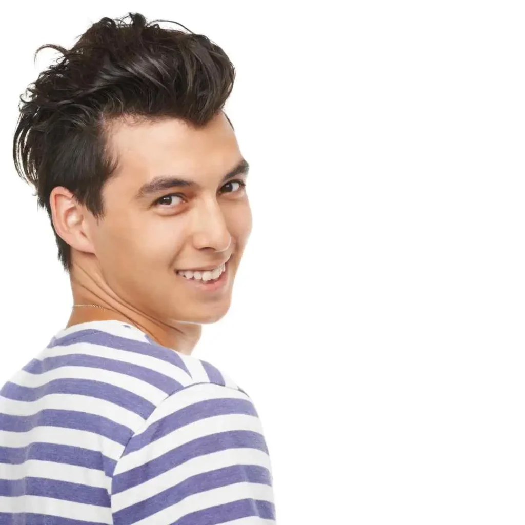 52 Mid-Length Hairstyles for Men- A Comprehensive Guide. 1 A person in a striped shirt looks over their shoulder, showcasing a stylish men's medium-length hairstyle against a plain backdrop.