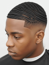 A man with a black haircut featuring a temple fade and styled 360 waves.