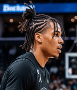 A basketball player sporting dreadlocks styled in braids, focused on the game.