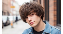 A young man in a denim jacket with short hair, representing a Mod haircut for men.